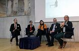 Das Bild zeigt eine Gruppe von Referierenden auf dem Podium im Festsaal.