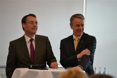 Landesminister Peter Friedrich und Roland Bleinroth stehen hinter einem Tisch.