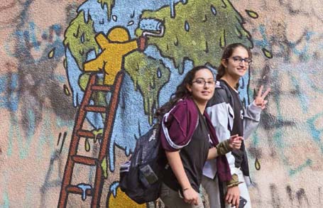 Das Bild zeigt zwei Jugendliche vor einem Graffiti in Beirut.