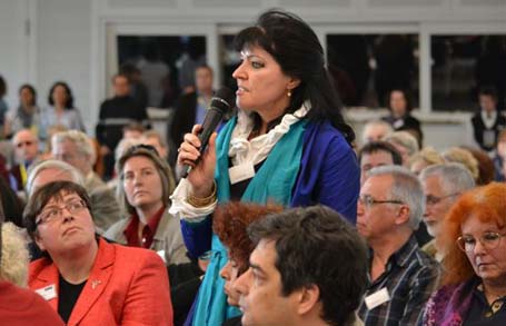 Das Bild zeigt eine Frau im Plenum, die eine Frage stellt.