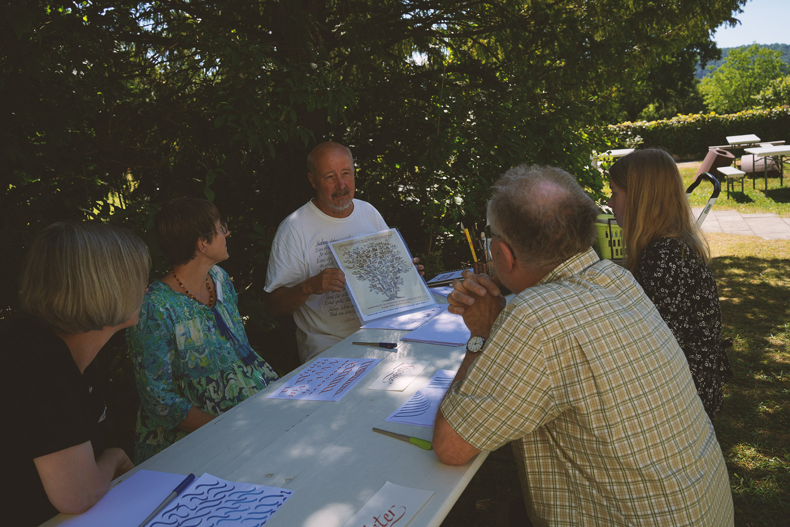 Teilnehmende der Sommerakademie an einem Tisch.